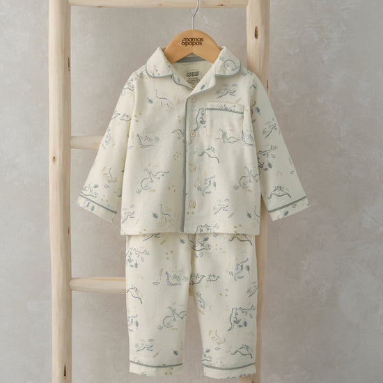 A pair of traditional button up pyjamas is hanging from a wooden ladder.